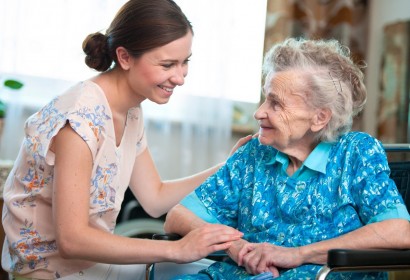 Elderly woman on wheelchair with a nurse