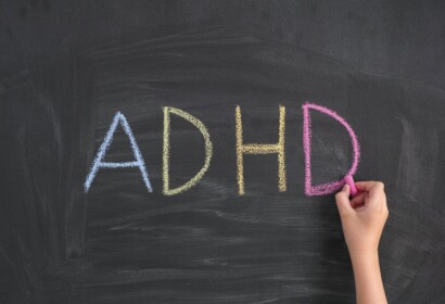 ADHD. Child writing Abbreviation ADHD on a blackboard. ADHD is Attention deficit hyperactivity disorder.