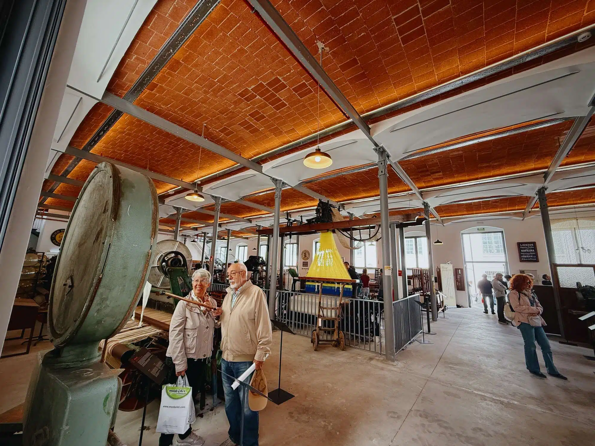 Visitants observant la maquinària tèxtil de Can Manyer durant una visita guiada Interior de Can Manyer amb visitants
