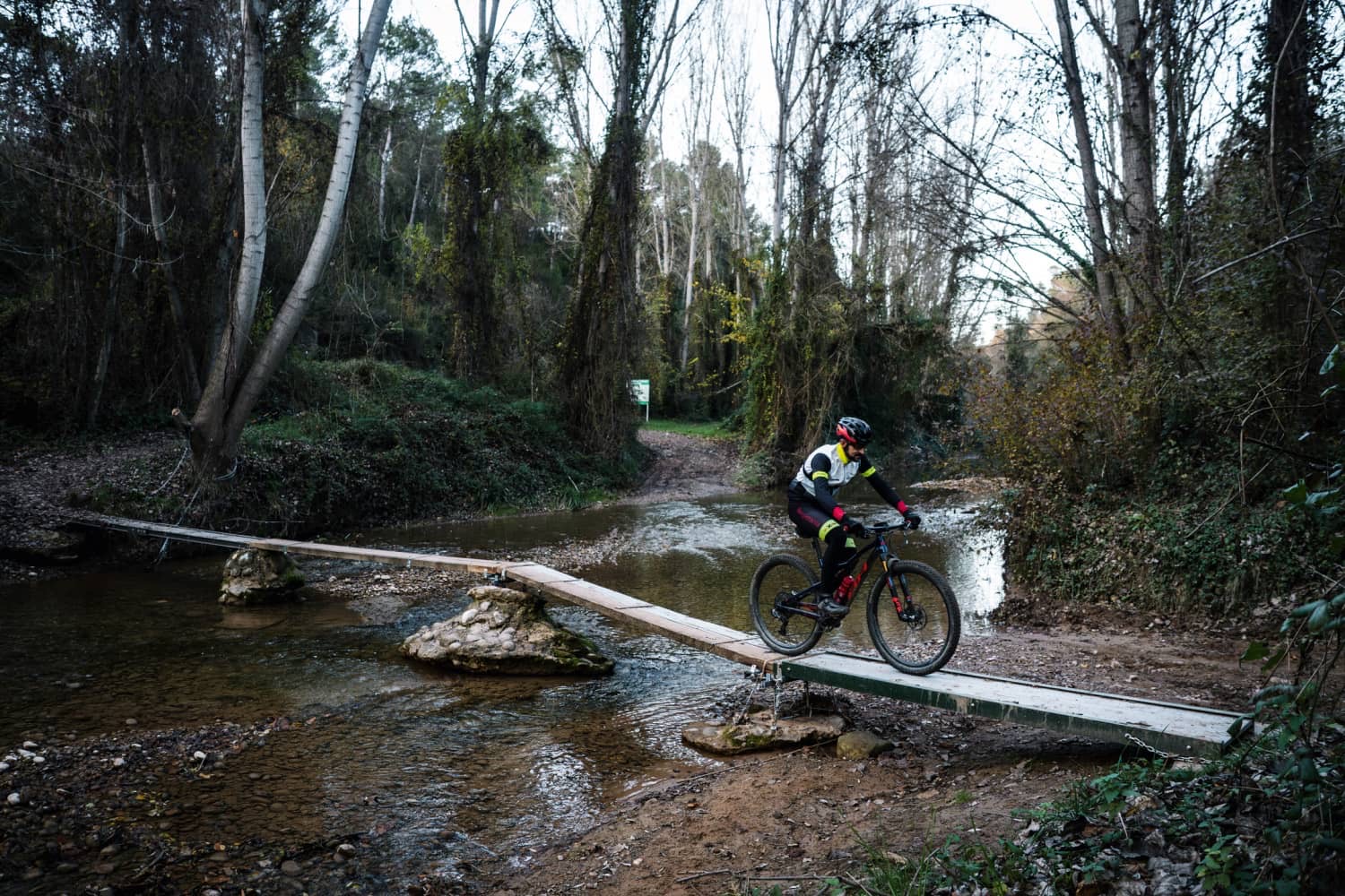 Ciclista de muntanya creuant una passarela de fusta