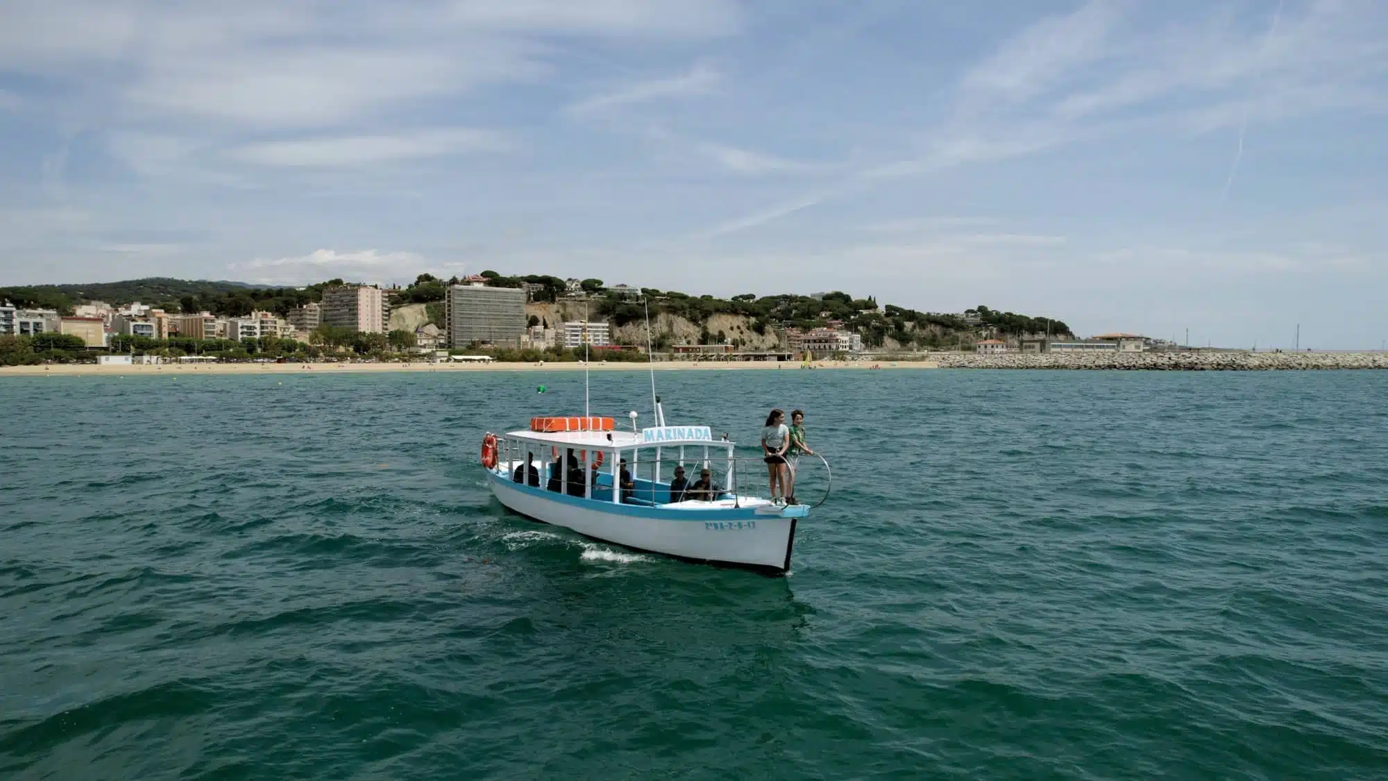 Embarcació turística navegant a la costa