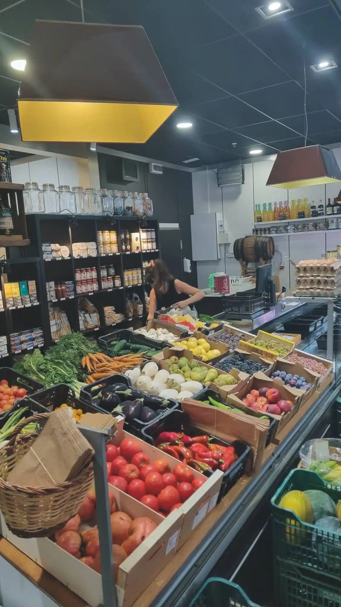 Interior del mercat o establiment amb productes frescos disposats en caixes i mostradors