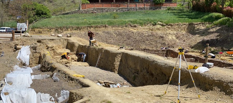 Pla obert d'una part del fòrum romà 'Iulia Libica' excavada i, al fons, un equip d'arqueòlegs treballant en aquest jaciment situat a Llívia (Cerdanya). Imatge del 20 de maig de 2021. (Horitzontal).