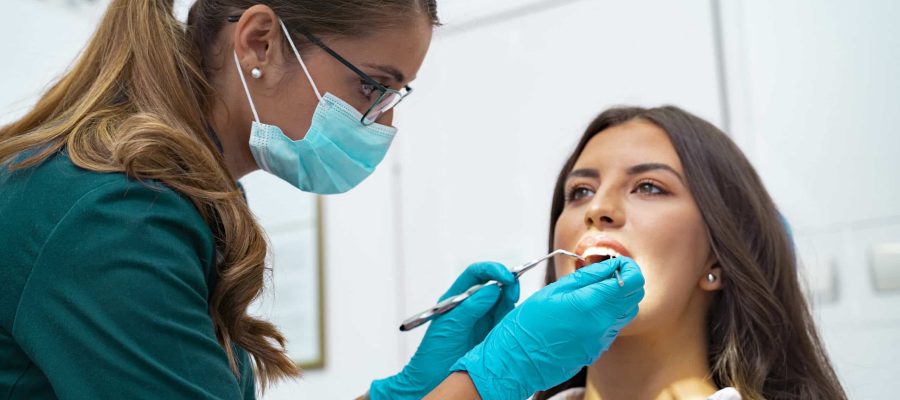 Closeup shot professional dentist with protective surgical mask, doing check up of patient