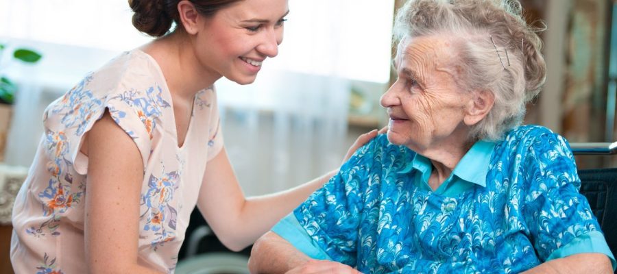 Elderly woman on wheelchair with a nurse