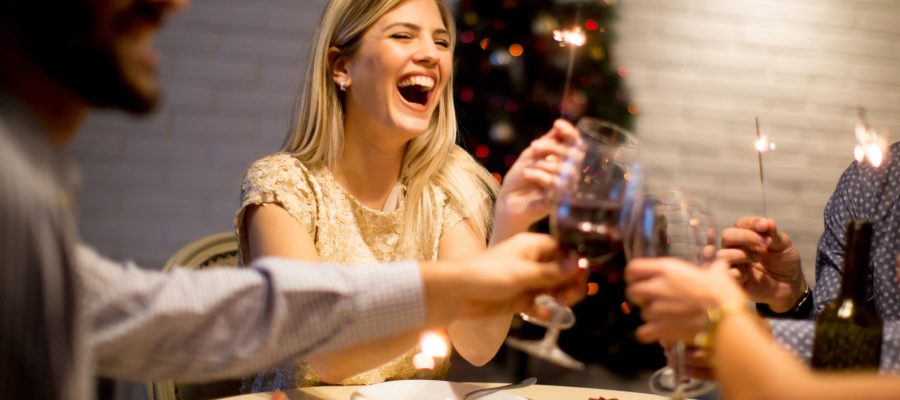 Group of young people celebrating New Year and drinking red wine