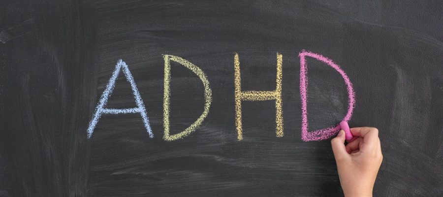 ADHD. Child writing Abbreviation ADHD on a blackboard. ADHD is Attention deficit hyperactivity disorder.