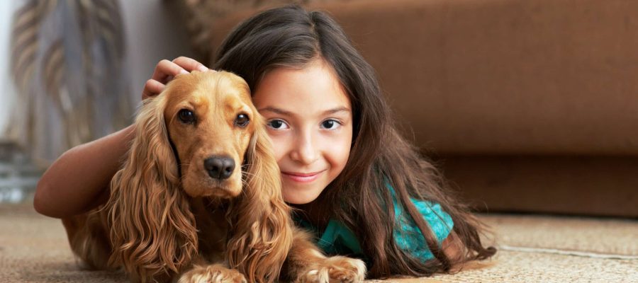 The girl is lying on floor with dog